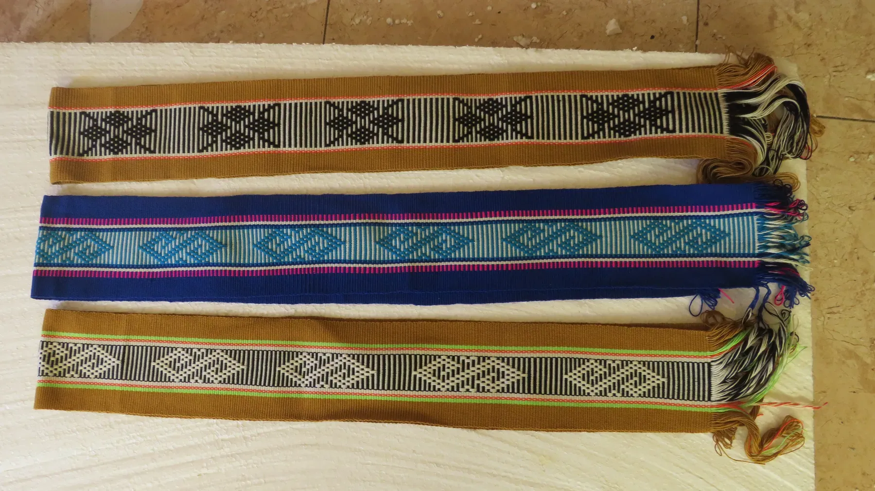 Tres chumbes extendidos con sus flecos rematados a mano