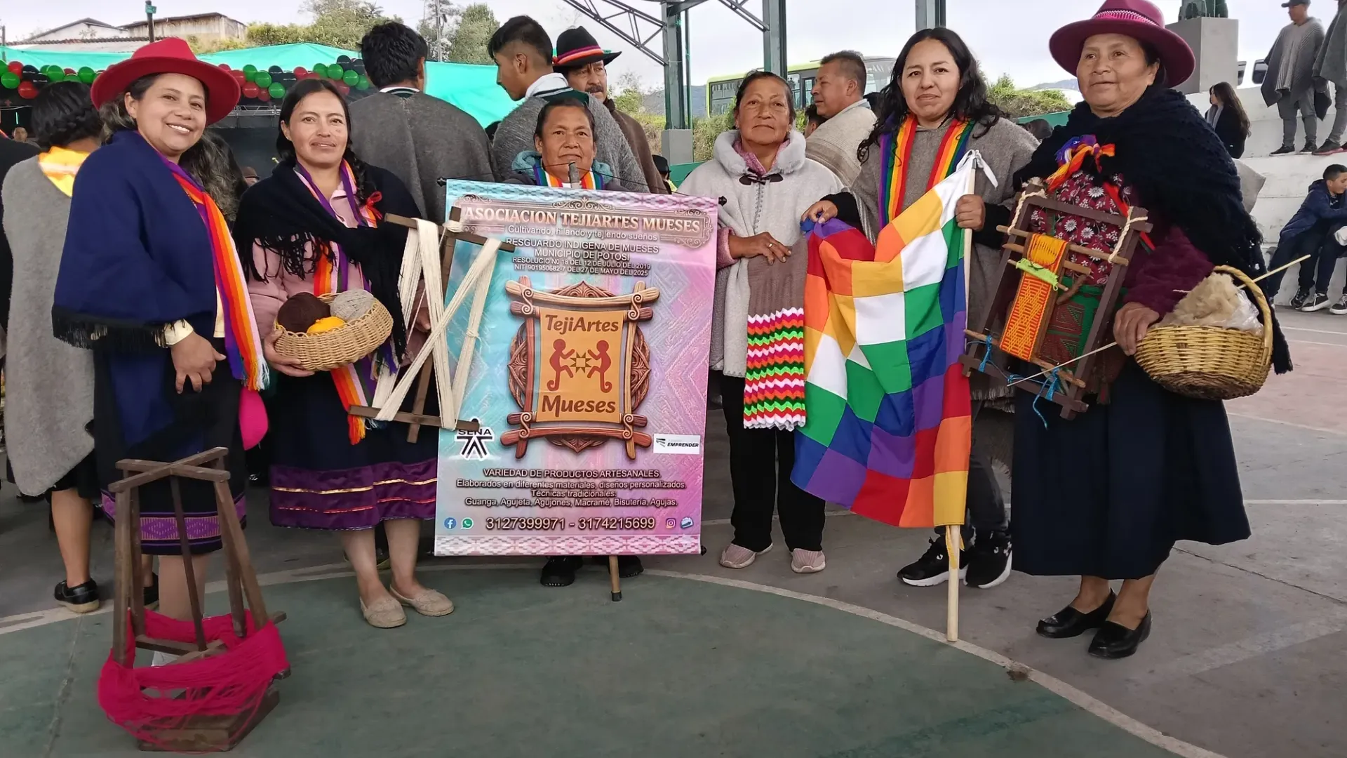 Tejedoras de TejiArtes Mueses con el pendón de la asociación en una feria