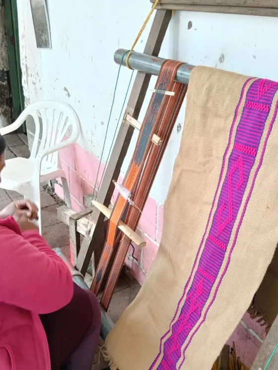 Tejedora tejiendo una prenda en la guanga horizontal