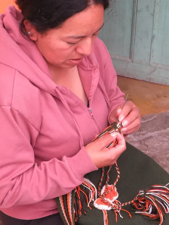 Tejedora trabajando accesorios en macramé
