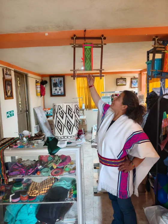 Tejedora en el taller con una prenda del grupo
